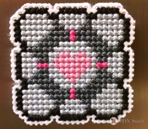 photograph of cross stitched portal companion cube magnet