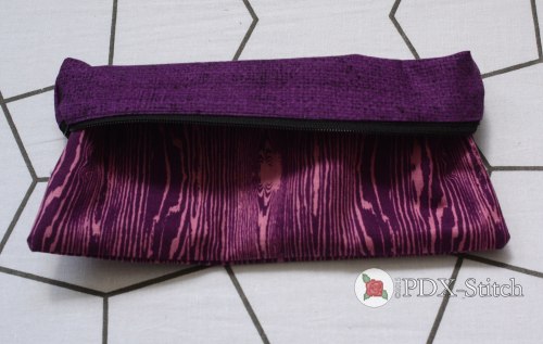 picture of purple woodgrain zippered pouch turned partly inside out to show the purple printed lining