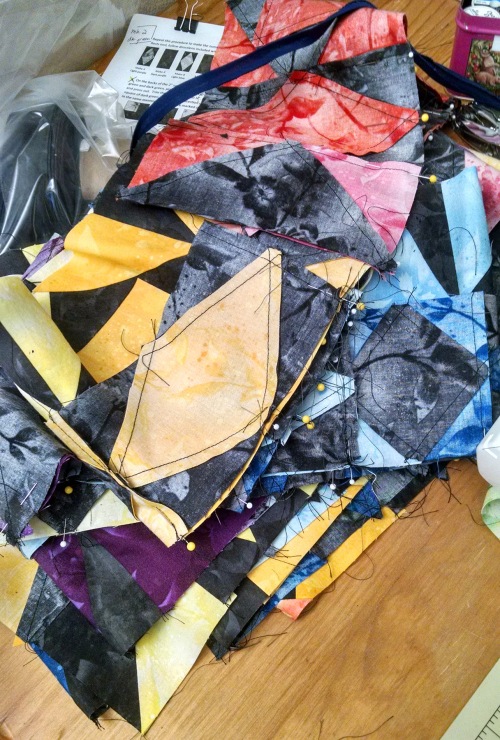 A pile of many-colored quilt squares on a wooden table